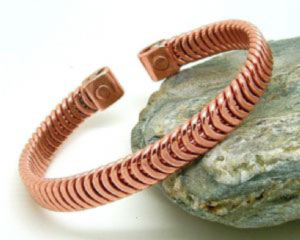 A copper herringbone design made from light copper wire wound together and flattened. Each tab end is fitted with a rare earth magnet